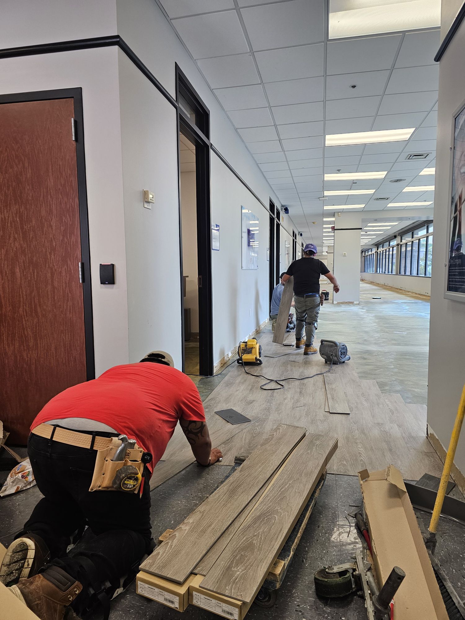 Office remodeling contractors laying flooring.